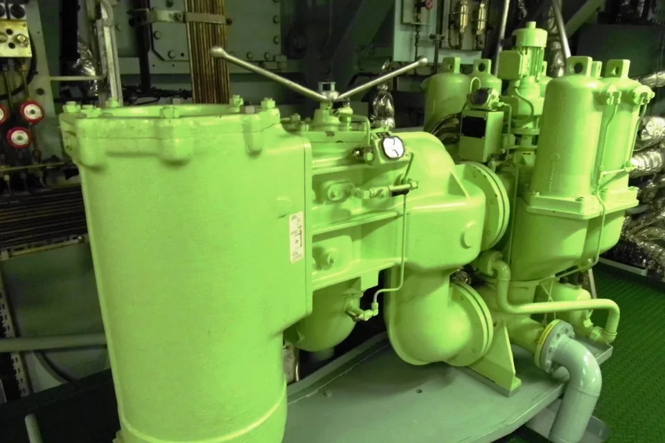 Automatic lube oil filter unit in a container ship engine room, duplex filter housings with pressure gauges and flanged pipework on a painted seating