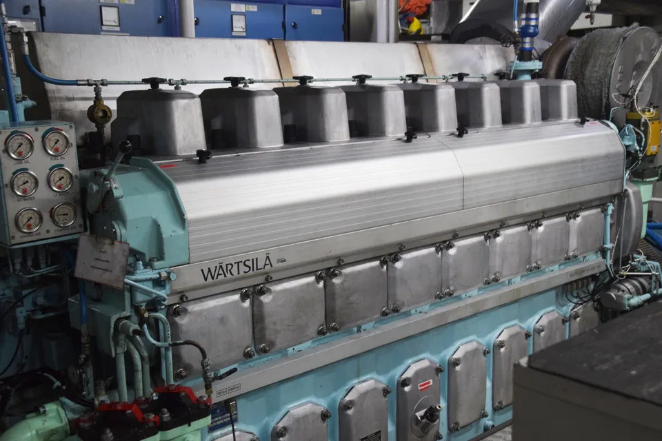 Wärtsilä 8L20 marine auxiliary diesel engine in a ship engine room, manufacturer name cast on the block